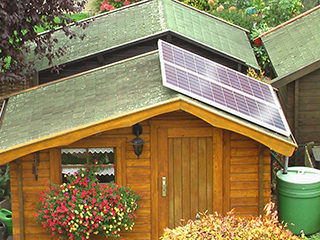 Eine Solaranlage mit zwei Modulen auf dem Dach einer Gartenlaube