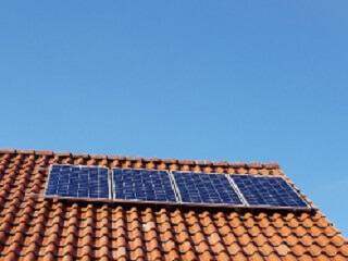 Eine kleine Solaranlage, bestehend aus vier Solarpanels am Schrägdach mit Frankfurter Pfanne.